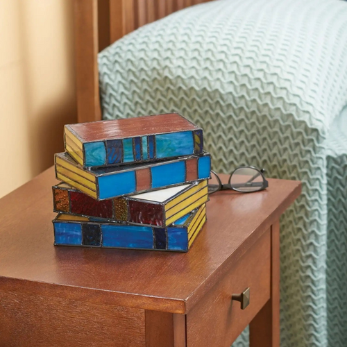 Stained glass table lamp in the shape of an open book with warm glowing light