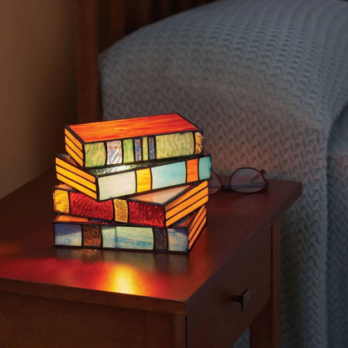 Stained glass table lamp in the shape of an open book with warm glowing light